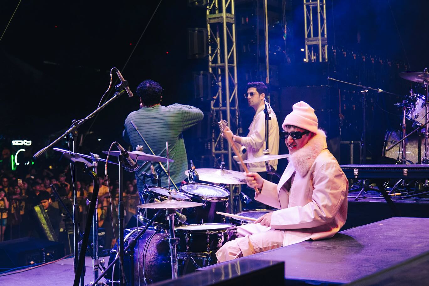 Refugee tocando en vivo en una tarima con baterías y banda